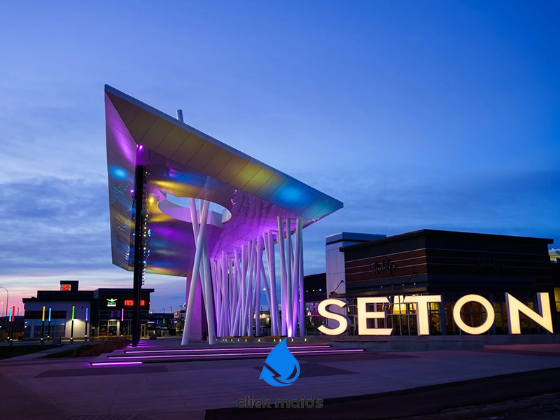 Modern architectural canopy structure lit purple at dusk in Seton, Calgary, with the large 'SETON' sign visible.