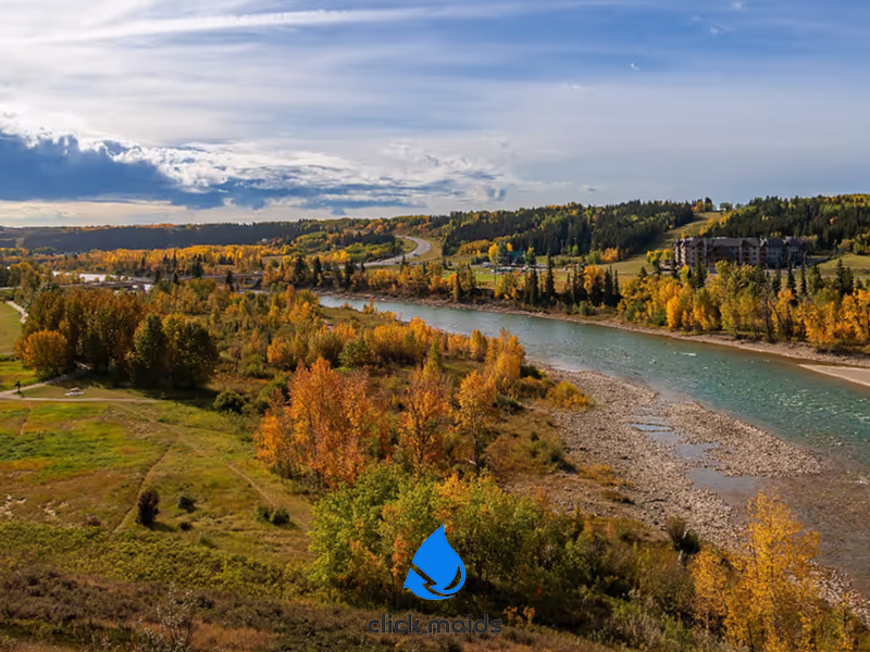 Scenic river valley in Alberta with fall foliage, winding roads, and colorful trees under a bright sky